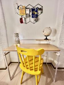 żółte krzesło siedzące przed drewnianym stołem w obiekcie Casa Myrtos w mieście Palermo +6 zdjęć