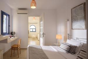 1 dormitorio con cama, escritorio y silla en Kamares Apartments en Fira