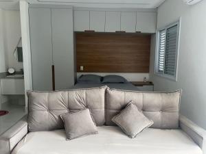 a couch with two pillows sitting in a bedroom at Apartamento Studio em São Bernardo in São Bernardo do Campo
