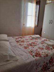 a bedroom with a bed with a flowered blanket at Villino Maria Vittoria in Castellammare del Golfo