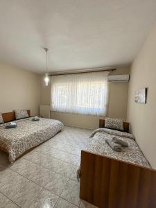 a room with two beds and a window at Faros Axd Odysseus Apartment in Alexandroupoli