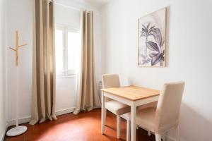mesa y sillas en una habitación con ventana en Sunny rooms bcn, en Barcelona
