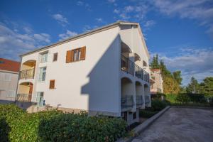 a large white building with a parking lot at Apartments Plenković in Stari Grad