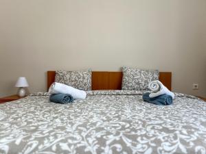 a bed with two towels and a stuffed animal on it at Ground Apartment AXD in Alexandroupoli