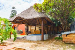 an outdoor umbrella with a table and chairs at Homes of Ace 3 bedroom Villa in Pretoria