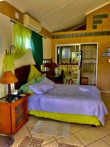 a bedroom with a bed and a table with a lamp at Five Stars Lodge in Phalaborwa