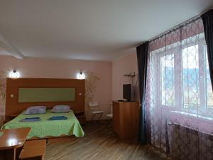 ein Schlafzimmer mit einem Bett und einem großen Fenster in der Unterkunft Вілла На Гірській in Schidnyzja