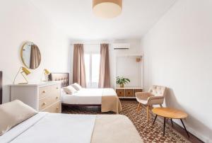 una habitación de hotel con 2 camas y una silla en Sunny rooms bcn, en Barcelona
