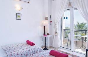 a bedroom with a bed with pink pillows and a balcony at Villa Francesca in Kalathos