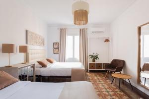 1 dormitorio con 2 camas, escritorio y silla en Sunny rooms bcn, en Barcelona