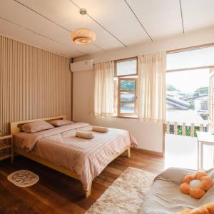 a bedroom with two beds and a large window at Just renovated in walking street in Chiang Khan