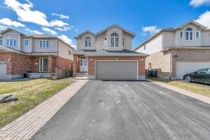 a large house with a garage in the driveway at Cozy Luxurious Detached 4 Bedroom House in Guelph