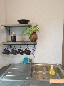 a sink in a kitchen with a shelf above it at Just renovated in walking street in Chiang Khan