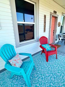 two chairs sitting on the front porch of a house at The Poolside Bungalow in Galveston