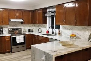 a kitchen with wooden cabinets and a marble counter top at Cozy Luxurious Detached 4 Bedroom House in Guelph