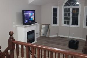 a living room with a television and a fireplace at Cozy Luxurious Detached 4 Bedroom House in Guelph