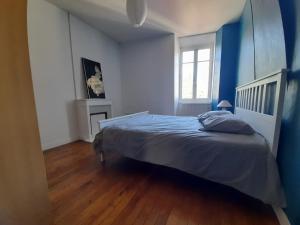um quarto com uma cama e uma parede azul em Magnifique maison avec terrasse em Château-Thierry