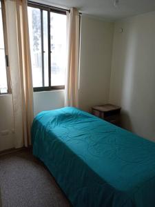 a bedroom with a blue bed and a window at Genial Ubicación, cerca de todo! in La Serena