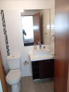 a bathroom with a toilet and a sink and a mirror at Genial Ubicación, cerca de todo! in La Serena