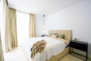 sypialnia z dużym łóżkiem z białą pościelą w obiekcie Mara's Apartments Higueron West - Mediterranean Style - Beach & Golf - Large Sunny Terrace !!!! w mieście Fuengirola