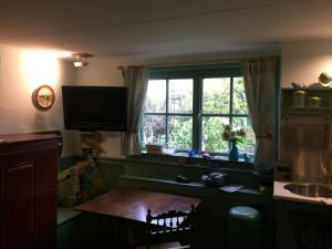 a kitchen with a table and a large window at B&B Bij de Boomgaard in Tricht