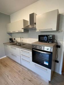 a kitchen with a stove and a sink and a microwave at Apartment Sweet Retreat in Dro