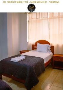 a hotel room with two beds and a window at Hospedaje Moralillos in Yurimaguas