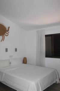 Un dormitorio con una cama blanca con un pez en la pared en Relaxing Bungalow Playa del Inglés en Maspalomas