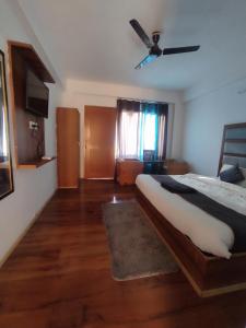 een slaapkamer met een bed en een plafondventilator bij The King Hill in Ketti