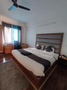 a bedroom with a large bed with white sheets and pillows at The King Hill in Ketti