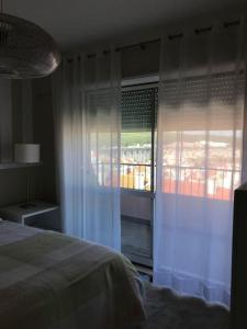 - une chambre avec un lit et une grande fenêtre dans l'établissement NEW Monsanto View Charming Apartment @ Campolide - 3B, à Lisbonne