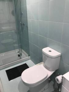 La salle de bains est pourvue d'une douche et de toilettes blanches. dans l'établissement NEW Monsanto View Charming Apartment @ Campolide - 3B, à Lisbonne