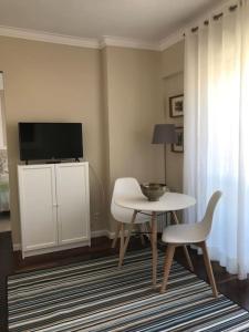 - un salon avec une table et une télévision dans l'établissement NEW Monsanto View Charming Apartment @ Campolide - 3B, à Lisbonne
