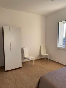 two chairs and a cabinet in a room with white walls at B&B AnnaVi in Bologna