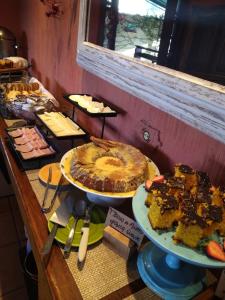 uma mesa com vários tipos diferentes de bolos e sobremesas em Pousada Benevento em Campos do Jordão