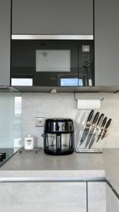 uma cozinha com um balcão e um micro-ondas em Modern 14th Floor 1or2-Bed Flat em Dagenham