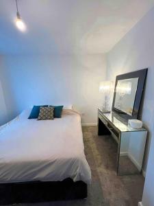 um quarto com uma cama e uma secretária com um espelho em Modern 14th Floor 1or2-Bed Flat em Dagenham