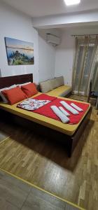 een slaapkamer met een groot bed met rode kussens bij Center Apartment Delfina in Ohrid