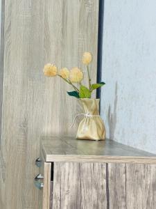 a vase with yellow flowers sitting on a table at Guest House Royal Comfort With Terrace in Kutaisi