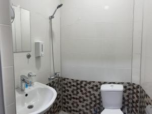 Baño blanco con lavabo y aseo en Guest House Royal Comfort With Terrace, en Kutaisi