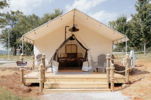 a tent with a porch with two chairs in it at XLg Porch Deluxe glamping tents @ Lake Guntersville State Park in Guntersville