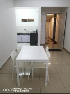 un tavolo bianco con sedie in una stanza di Rizqi Homestay Seruling a Putrajaya
