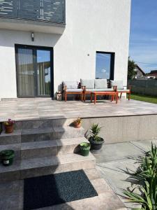 a patio with two couches and a table and benches at Mimi house in Baia de Fier +3 photos