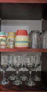 uma fila de copos e taças numa prateleira em Center Apartment Delfina em Ohrid