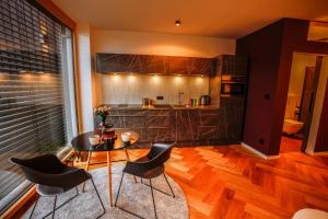 cocina con mesa y sillas en una habitación en Der Schwarzbau - Luxus Ferienhaus mit Pool und Sauna, en Runding
