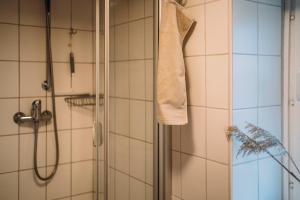 a bathroom with a shower with a towel hanging on the wall at Kalle´s Reethus in Pellworm