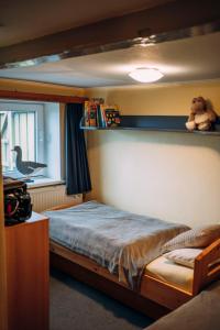 a bedroom with a bed with a teddy bear on a shelf at Kalle´s Reethus in Pellworm