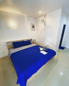 a bedroom with a blue bed in a white room at Sun & Sea Nai Yang Phuket in Nai Yang Beach