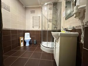 a bathroom with a toilet and a shower and a sink at SPA HOTEL Gora in Bukovel