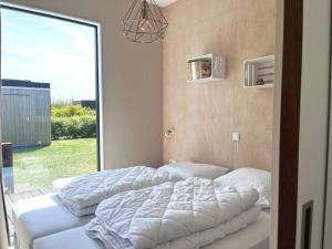 two beds in a room with a large window at Nieuw Noorderland op Terschelling in Midsland